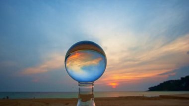 Gün batımında adanın manzarası kristal küre içinde bir kum yığını üzerinde. Plaj videosundaki kristal küre yerinde gün batımı. Doğa videosu doğa ve seyahat konseptinde yüksek kaliteli görüntüler.