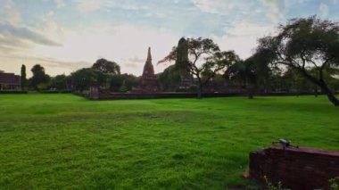 Dini Tarih Parkı 'ndaki kil tuğlalardan yapılmış eski bir kemer. Ayutthaya döneminde Wat Phra Ram başkentti. Mavi gökyüzünde güneşin doğuşunu gösteren beyaz bulutlar. Tarihi bir çağda olmak gibi.