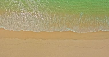 Havadan görünen deniz dalgaları beyaz kumsalda kusursuz bir döngü oluşturuyor.