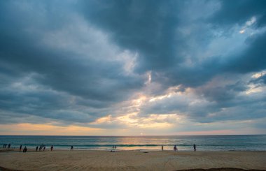Güneş batarken sersemletici bulutlar denizin üzerinde süzülür.