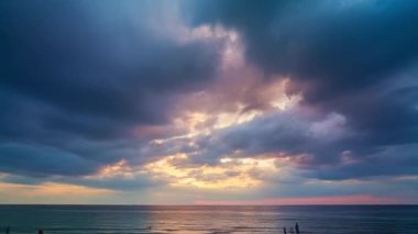Zaman atlamalı bulutlar gün batımında denizin üzerinde yüzerler. Batan güneş tarafından aydınlatılan bulutlar güzel ve sakin bir atmosfer yaratır. Anın güzelliği nefesini keser.