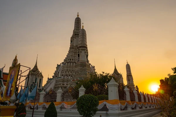 stock image scenery sunset behind the large illuminated temple Wat Arun the biggest and tallest pagoda in the world beside Chaophraya river Bangkok, Thailand