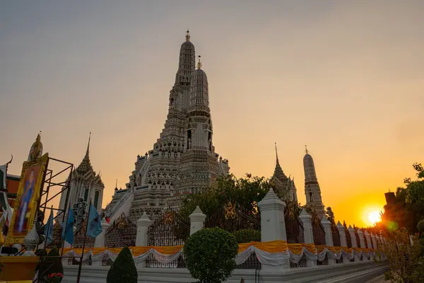 stock image scenery sunset behind the large illuminated temple Wat Arun the biggest and tallest pagoda in the world beside Chaophraya river Bangkok, Thailand