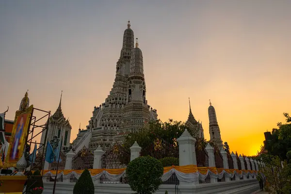 stock image scenery sunset behind the large illuminated temple Wat Arun the biggest and tallest pagoda in the world beside Chaophraya river Bangkok, Thailand