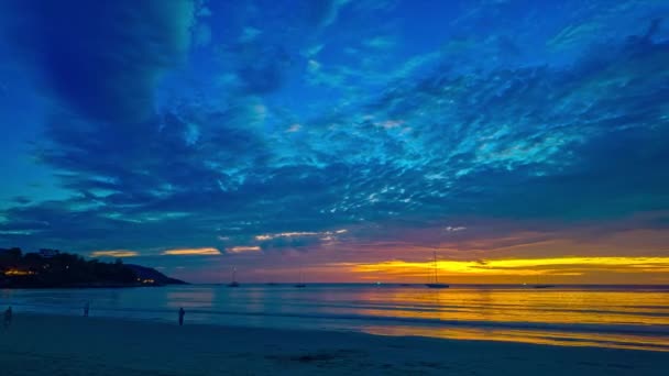 夕方には島の上空に青い雲が飛び出しています カタビーチプーケットでプー島の後ろに下る青空の黄色い太陽 — ストック動画
