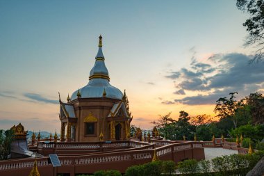 Güneşin ışıkları ve renkli günbatımları güzel pagodanın üstündeki gökyüzünde beliriyor. Dağın tepesinde Phuket Tapınağı 'nın arkasındaki tapınağın tepesinde.
