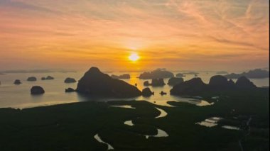 Hava hiperlapse görüntüsü gün doğumunda parlak sarı bir gökyüzü hayal edin. Güneş ışığı adalarda parlıyor. Güzel Phang Nga Körfezi 'nin çarpıcı hava manzarası.