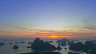 Hava hiperlapse görüntüsü gün doğumunda parlak sarı bir gökyüzü hayal edin. Güneş ışığı adalarda parlıyor. Güzel Phang Nga Körfezi 'nin çarpıcı hava manzarası.