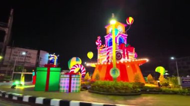 Phuket şehrinde Noel gecesi, Tayland-Aralık, 31,2023: Phuket döner kavşağı güzel binaların saat kulesindeki muhteşem renkli ışıklandırma gösterisinde güzel ışıklarla süslenmiştir..