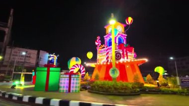 Phuket şehrinde Noel gecesi, Tayland-Aralık, 31,2023: Phuket döner kavşağı güzel binaların saat kulesindeki muhteşem renkli ışıklandırma gösterisinde güzel ışıklarla süslenmiştir..