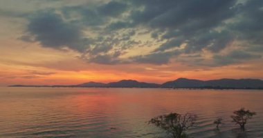 Khao Khad Phuket 'teki okyanusun üzerindeki parlak günbatımı gökyüzünde renkli bulutların hava görüntüsü. Muhteşem gün batımı ya da gün doğumu manzarası. Doğanın inanılmaz ışığı. fantastik gökyüzü dokusu.