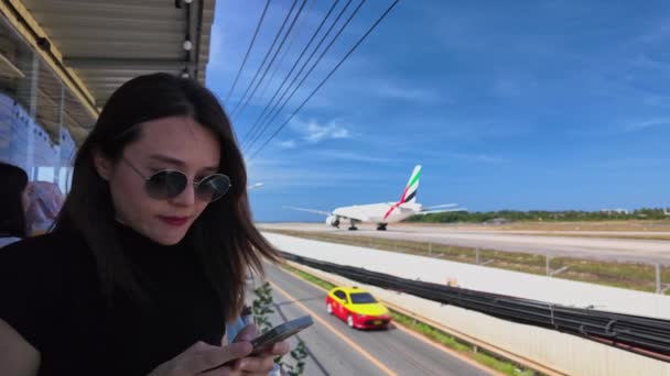Uma Mulher Observa Avião Pista Lado Aeroporto Enquanto Ele Passa — Vídeo de Stock