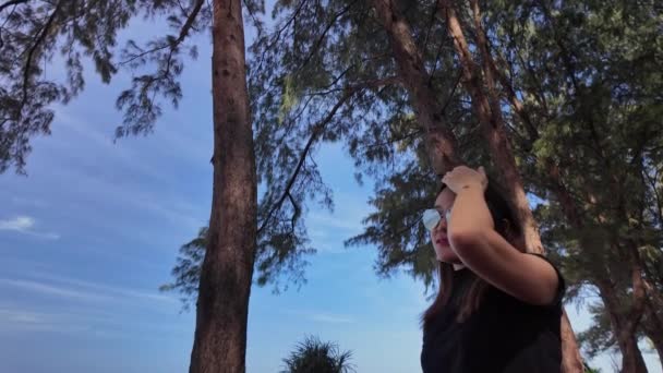 Жінка Щасливо Ходить Уздовж Пляжу Під Великим Сосновим Деревом — стокове відео