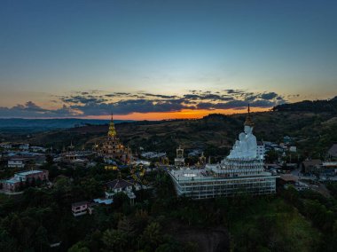 Hava manzarası gün batımında muhteşem Büyük Beyaz Buda heykelleri. Wat Phachonkeaw 'un güzel altın köşkü Tayland' ın çok güzel ve ünlü bir simgesi olan tepede mücevherler ve taşlarla süslenir..