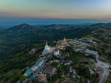 Hava manzarası gün batımında muhteşem Büyük Beyaz Buda heykelleri. Wat Phachonkeaw 'un güzel altın köşkü Tayland' ın çok güzel ve ünlü bir simgesi olan tepede mücevherler ve taşlarla süslenir..