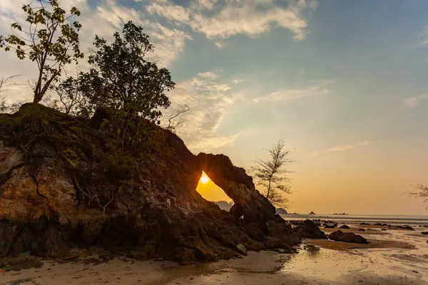 Güzel bir akşam güneşi parlıyor denizin üzerinde, cennetin kumsalında.