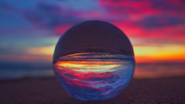 看日落时美丽的天空在海面上的水晶球里 — 图库视频影像