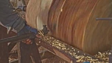 İşçiler odunların yüzeyini oymak için çelik çiviler kullanırlar.