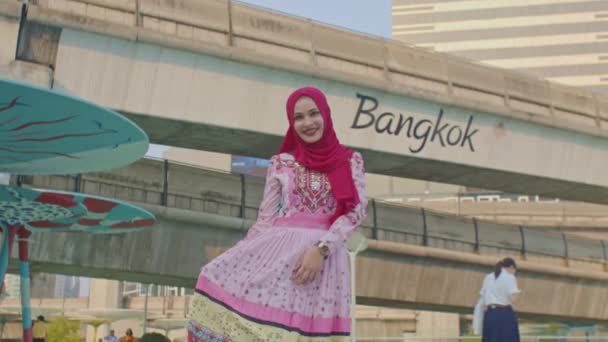 아름다운 무슬림 여성은 행복하게 방콕의 중심부에 여행하는 스카이 트레인으로 사진을 — 비디오
