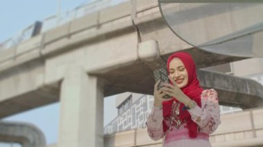 Bangkok, Tayland-Şubat, 22: 2022: Güzel bir Müslüman kadın Bangkok 'un göbeğinde seyahat ederken gökyüzü treniyle fotoğraf çektirmek için mutlu bir şekilde poz veriyor. - Başkent Bangkok 'ta refah. gökyüzü treni 