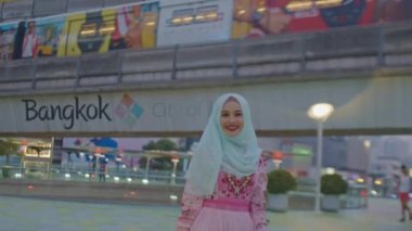 Bangkok, Tayland-Şubat, 22: 2022: Güzel bir Müslüman kadın Bangkok 'un göbeğinde seyahat ederken gökyüzü treniyle fotoğraf çektirmek için mutlu bir şekilde poz veriyor. - Başkent Bangkok 'ta refah. gökyüzü treni 