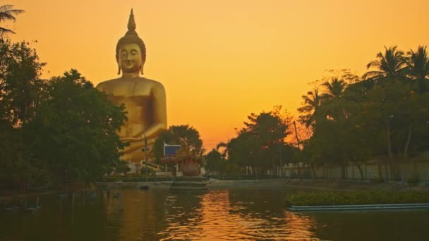 プールの黄色い空を反射する 最大の仏陀の背後にある日没の景色の黄色い空 ゴールデンビッグブッダ人気ランドマークウォータンアン トンタイ — ストック動画