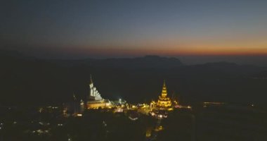 Hava manzaralı güzel Buda heykeli ve Wat Pha Sorn Kaew 'in altın rengi pagoda' sı altın bir günbatımında