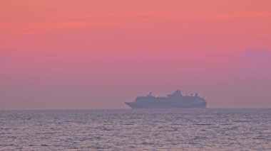 Altın yaz günbatımında okyanusta seyahat eden bir gemi.