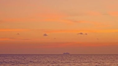 Altın yaz günbatımında okyanusta seyahat eden bir gemi.