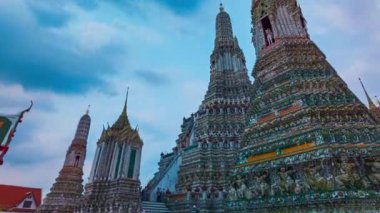 Wat Arun 'da zengin bir şekilde süslenmiş büyük pagodaların zaman atlaması. Pagoda Çin tarzında uygulanan Tayland mimarisidir. Jöleli fayanslar ve çok renkli ürünlerle süslenmiş. Wat Arun, Bangkok 'un simgesi.. 