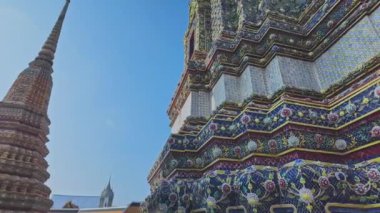 Wat Arun 'da zengin bir şekilde süslenmiş büyük pagodaların zaman atlaması. Pagoda Çin tarzında uygulanan Tayland mimarisidir. Jöleli fayanslar ve çok renkli ürünlerle süslenmiş. Wat Arun, Bangkok 'un simgesi.. 
