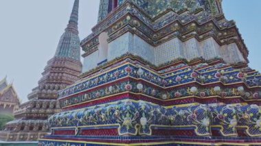 Wat Arun 'da zengin bir şekilde süslenmiş büyük pagodaların zaman atlaması. Pagoda Çin tarzında uygulanan Tayland mimarisidir. Jöleli fayanslar ve çok renkli ürünlerle süslenmiş. Wat Arun, Bangkok 'un simgesi.. 