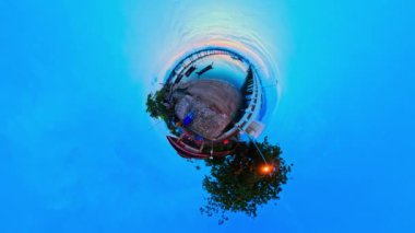 Küçük Gezegen 4K Stok 360 Derece Görünümü. Adanın üstündeki renkli sarı ışıkta zaman aşımı. Chalong rıhtımının üstündeki bulutların arasından göz kamaştırıcı güneş parlıyor. Grafik renkleri.