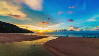 Sahildeki su birikintisinde gün batımında gökyüzünün aşırı yansıması. Güneşin ışınları su birikintisinde parladı büyüleyici bir renk dansı yarattı.