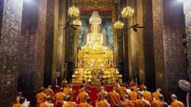 Bangkok, Tayland - 10 Nisan 2024: Keşişler, Wat Bowonniwet Vihara 'nın başlıca Buda imajının önündeki kilisede ilahi dualarına katıldılar.