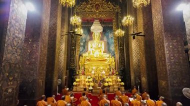 Bangkok, Tayland - 10 Nisan 2024: Keşişler, Wat Bowonniwet Vihara 'nın başlıca Buda imajının önündeki kilisede ilahi dualarına katıldılar.