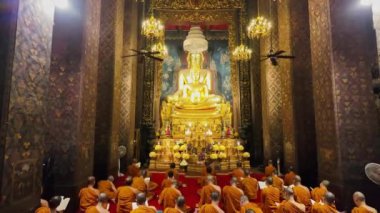 Bangkok, Tayland - 10 Nisan 2024: Keşişler, Wat Bowonniwet Vihara 'nın başlıca Buda imajının önündeki kilisede ilahi dualarına katıldılar.