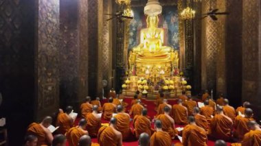 Bangkok, Tayland - 10 Nisan 2024: Keşişler Wat Bowonniwet Vihara şapelinde ana Buda resmi önünde dua ediyorlar.