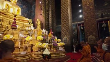 Bangkok, Tayland - 10 Nisan 2024: Keşişler Wat Bowonniwet Vihara şapelinde ana Buda resmi önünde dua ediyorlar.