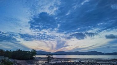 Chalong körfezinin üzerindeki gün batımında mavi bulutların zaman akışı..