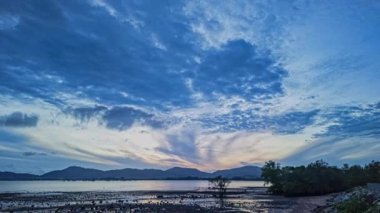 Chalong körfezinin üzerindeki gün batımında mavi bulutların zaman akışı..