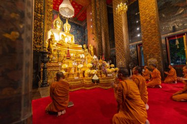 Bangkok, Tayland - 10 Nisan 2024: Keşişler Wat Bowonniwet Vihara şapelinde ana Buda resmi önünde dua ediyorlar.