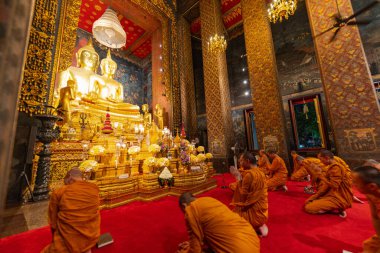 Bangkok, Tayland - 10 Nisan 2024: Keşişler Wat Bowonniwet Vihara şapelinde ana Buda resmi önünde dua ediyorlar.