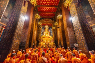 Bangkok, Tayland - 10 Nisan 2024: Keşişler Wat Bowonniwet Vihara şapelinde ana Buda resmi önünde dua ediyorlar.