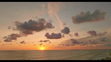 Phuket 'teki Maikhao plajı ve deniz üzerindeki hava manzaralı gün batımı manzarası.