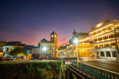 Turistler saat kulesine hayran, Phuket Town 'un merkezindeki Charter Kavşağı' ndaki güzel eski bir bina.