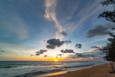 Phuket, Tayland 'daki Mai Kho plajında okyanusun üstünde gün batımı manzarası