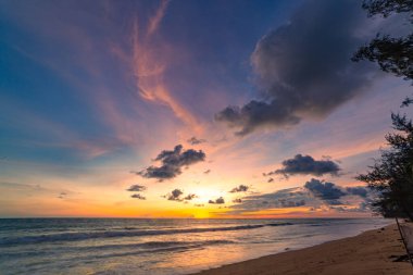 Phuket, Tayland 'daki Mai Kho plajında okyanusun üstünde gün batımı manzarası