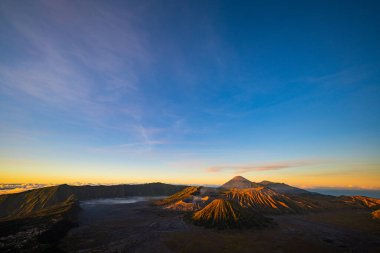 Güneşin doğuşunda mavi gökyüzü olan Bromo volkanları 