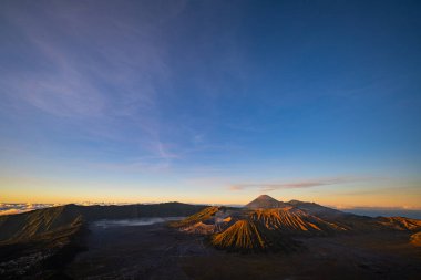 Güneşin doğuşunda mavi gökyüzü olan Bromo volkanları 
